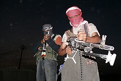 Two masked Iraqi men with weapons during the insurgency that followed the 2003 invasion of Iraq