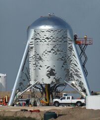 Short steel rocket with its fins touching the ground