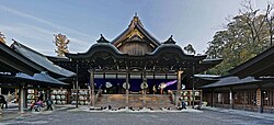 An image of Ise Grand Shrine Naikū, one of the large wooden shrines that make up the most sacred Shinto site in Japan. The site enshrines Amaterasu and there are many imperial symbols visible.