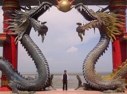 A visitor of Sanggar Agung Temple toke a picture under the dragon statues, Surabaya-Indonesia.jpg