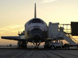 The Space Shuttle Discovery on the runway as ground crews work to get the crew out of the orbiter