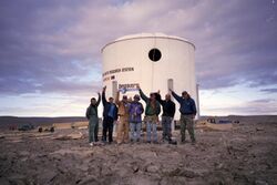 The completed exterior of the station on July 26, 2000. From left to right are Joe Amarualik, Joannie Pudluk, John Kunz, Frank Schubert, Matt Smola, Bob Nesson and Robert Zubrin.