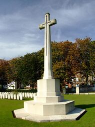 a stone cross with a metal longsword in the middle on an octagonal stone base.