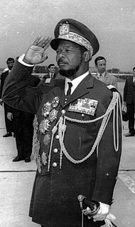 Jean-Bédel Bokassa stands saluting in military uniform