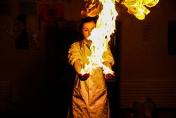 A young woman holding a flame in her hands