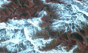 The Yarlung Tsangpo Grand Canyon from space, viewed from a somewhat oblique angle. The Yarlung Tsangpo river is seen coursing through the tall, sharp peaks of snow-capped mountains.