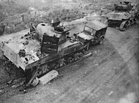 Two damaged tanks with their tracks visibly destroyed and a damaged Willy's Jeep displaying the 6th Armoured triangular flash