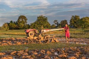 Boy plowing with a tractor at sunset in Don Det, Laos.