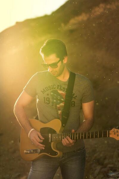 File:Man playing guitar in a portrait with lens flare.jpg