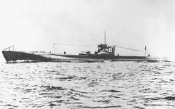 Large submarine running on the surface of the sea with a prominent deck gun and with radio mast raised