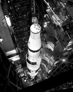 A rocket inside a high, narrow building with multiple levels surrounding it