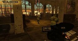 A man with carrying a video game walks behind two soldiers carrying guns into a large, desolate cathedral.