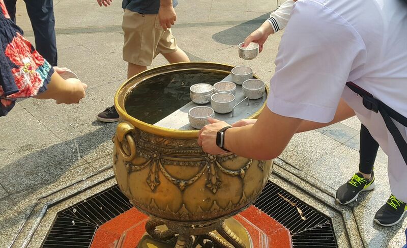 File:A Thai student pouring Holy water.jpg