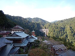 An image of Nachi Falls, part of the Kumano Nachi Taisha shrine complex, the waterfall is visible over a three-storied Buddhist pagoda.