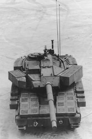 An AGS as seen from a high angle. The sides of the turret, track skirts and glacis plate are covered by thick boxes. The commander's station is armed with an M2 Browning .50 caliber machine gun.