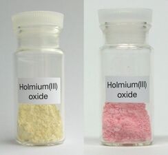 Samples of holmium(III) oxide under ambient light, and trichromatic light