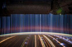 Streaks of light over a curved horizon.