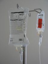 Photograph of two intravenous solution bags hanging from a pole.