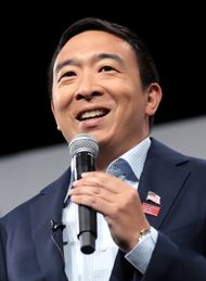 Andrew Yang holding a microphone while making a speech