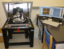 Picture of an atomic force microscope on the left with controlling computer on the right
