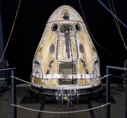A space capsule with burnt marks on sea