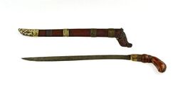 COLLECTIE TROPENMUSEUM Dolk met knievormig omgebogen houten greep en houten schede TMnr 674-615.jpg