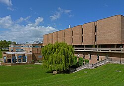 A photo depicting the outside of the library building for the University of Bradford, the sky is blue and the grass is green outside of the library in a closeby park.