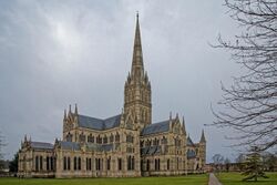 Salisbury Cathedral from the East showing features of the North Facade and grey masonry spire. The exterior shows the same harmony in the groupings of simple windows that is apparent in the interior view.