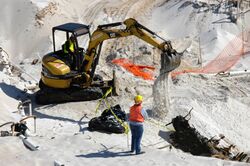 US Navy 060324-5328N-N-324 Using a mini excavator, a heavy equipment operator with the Pittsburgh, Pa.-based, Dick Corp. carefully covers the remains of a wrecked wooden ship aboard Naval Air Station Pensacola.jpg