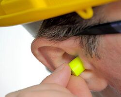Man inserting earplugs.jpg