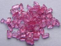 Several dozen pink, similar-sized rectangular crystals