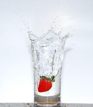 a glass of transparent water sitting on a wooden table