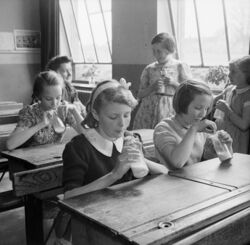 Girls at Baldock County Council School in Hertfordshire enjoy a drink of milk during a break in the school day in 1944. D20552.jpg